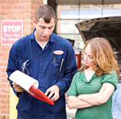 Auto service technician reviewing auto body services with customer